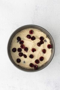 A cherry ricotta cake displayed on a white background.