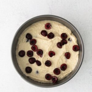 A cherry ricotta cake displayed on a white background.