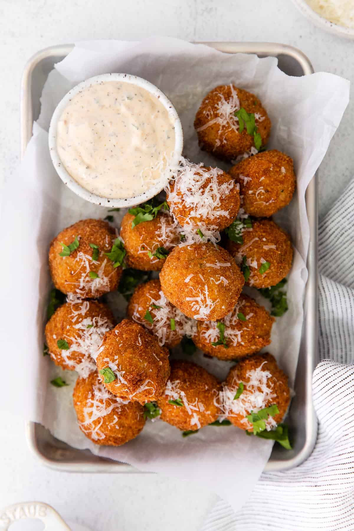 Arancini next to ranch dipping sauce.