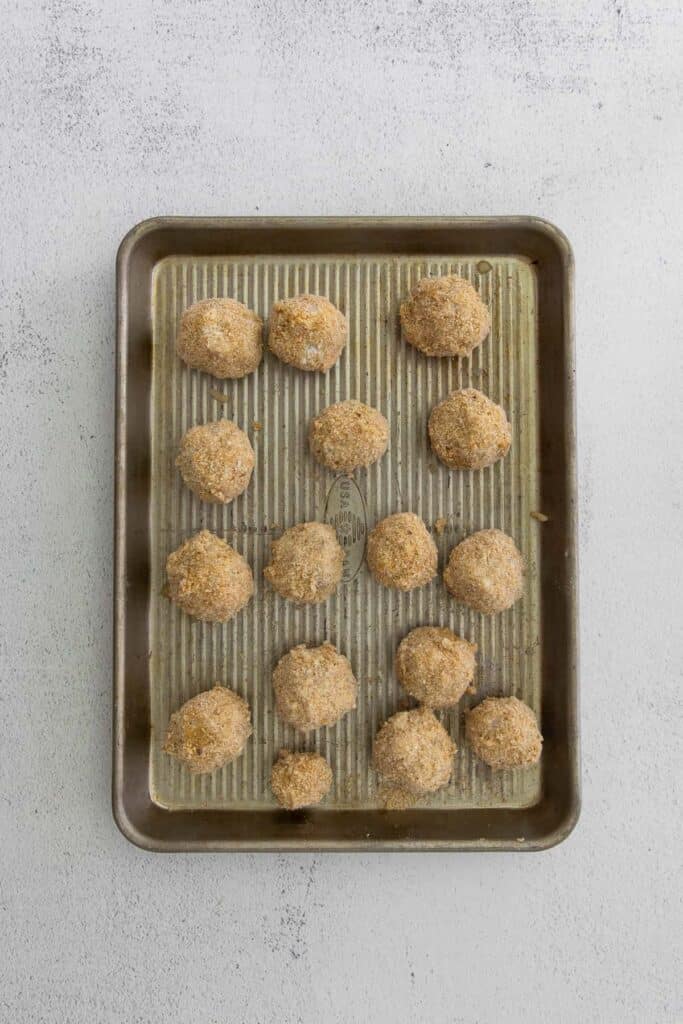 Uncooked arancini on platter.