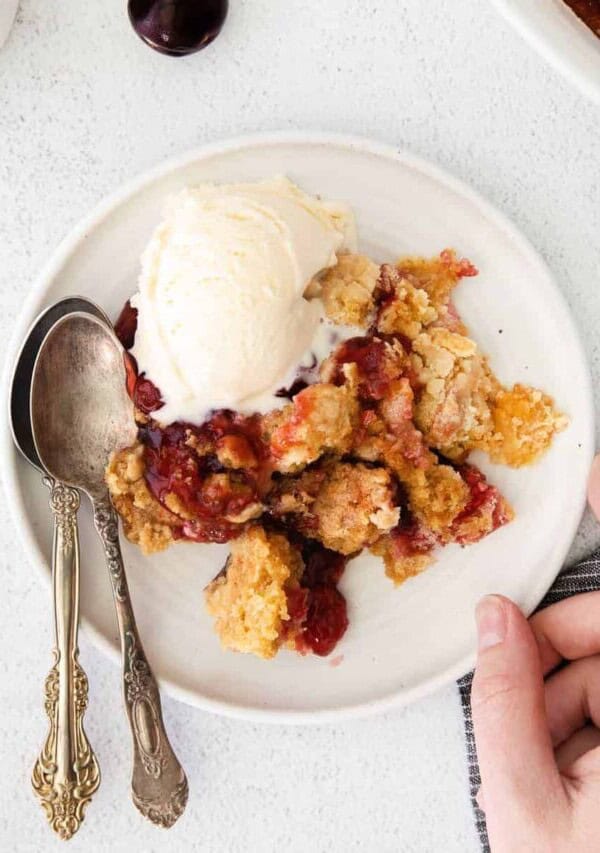 a plate of cream cheese cherry dump cake