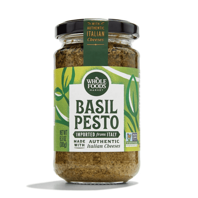 A jar of basil pesto on a white background, perfect for making pesto pasta salad.