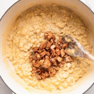 macaroni and cheese in a white pot with a spoon.