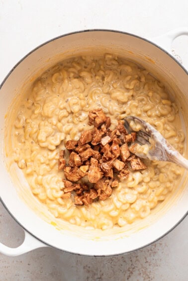 macaroni and cheese in a white pot with a spoon.