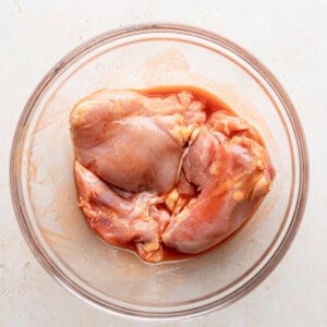 chicken in a glass bowl on a white surface.