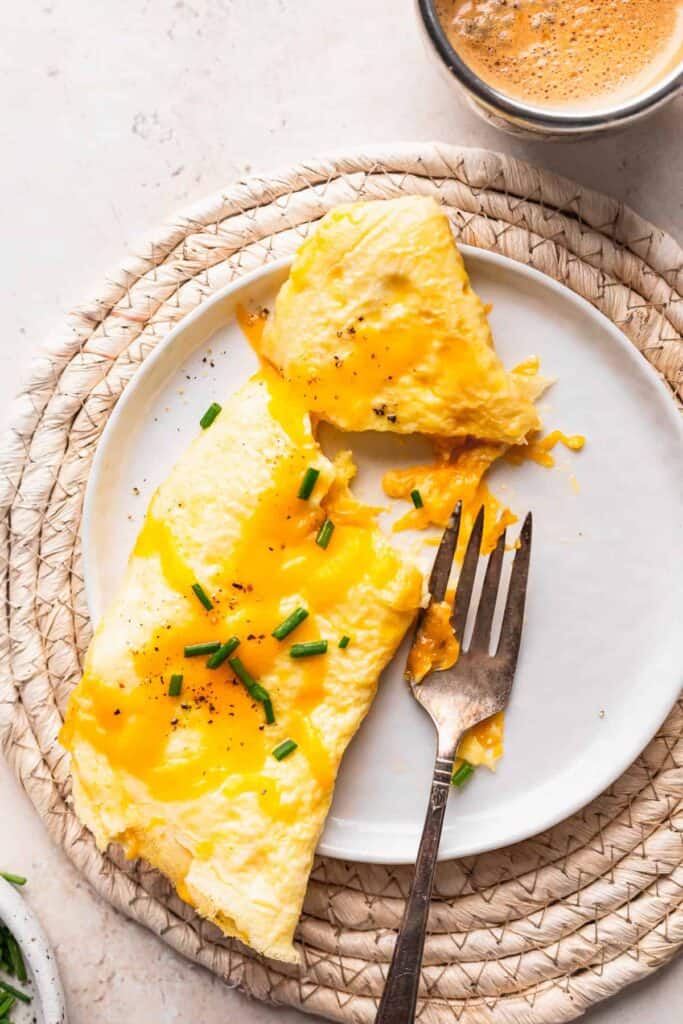 Cheese omelette on a plate with a fork.