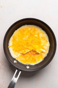 a cheese omelette frying in a pan.