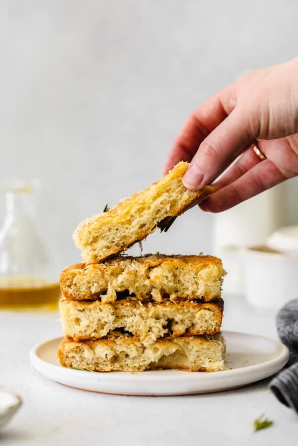 a hand grabbing a stack of bread.