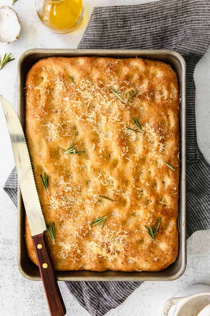 focaccia bread in pan with rosemary on top