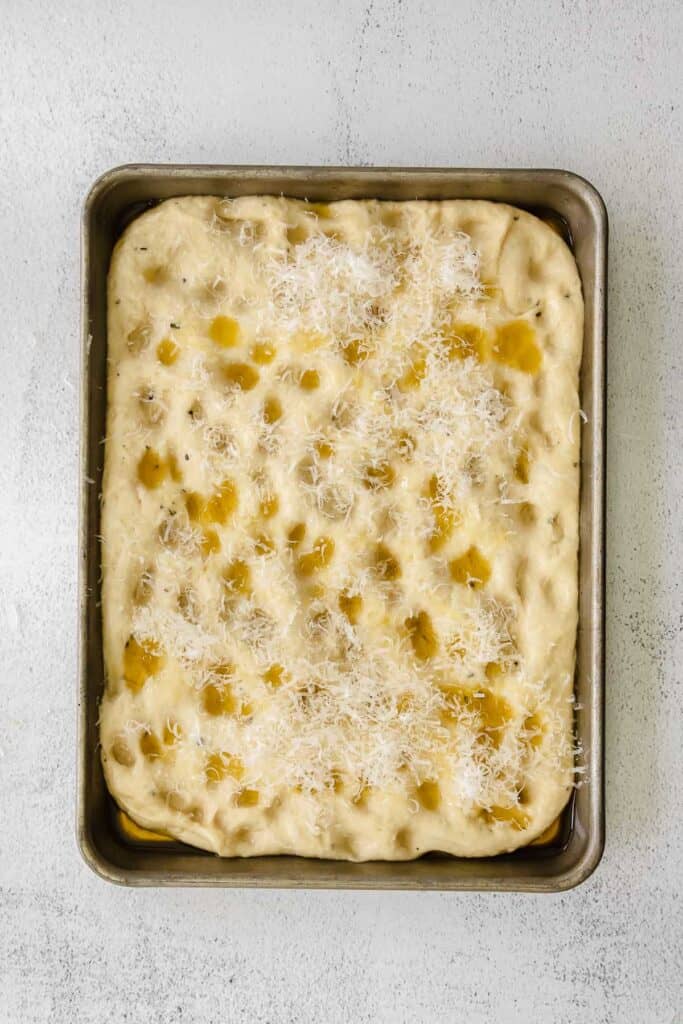 focaccia bread in pan with parmesan and olive oil