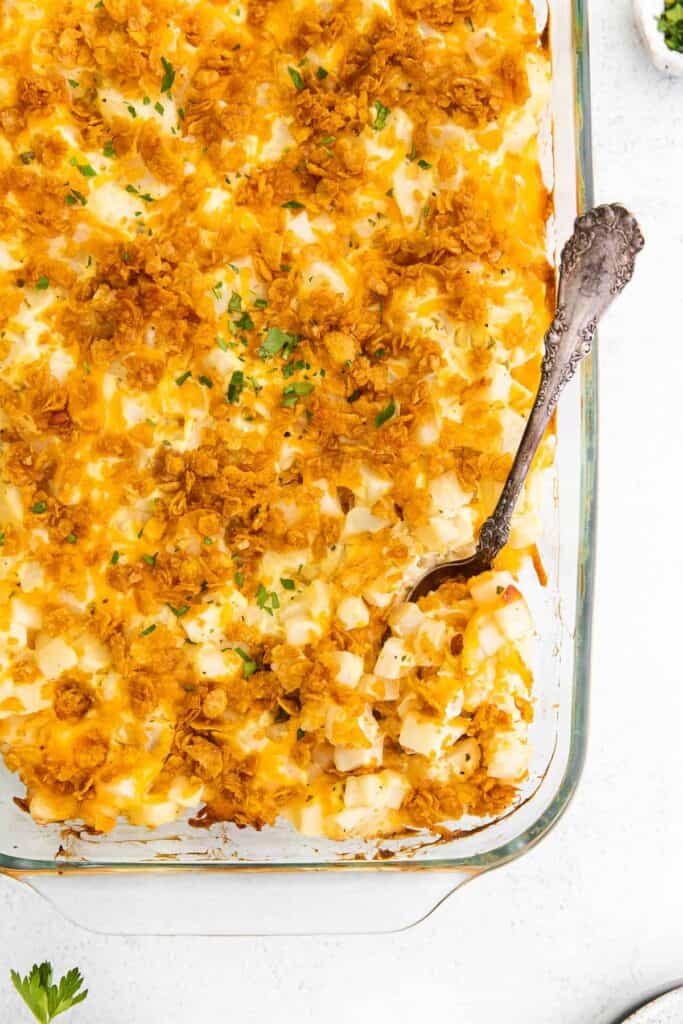 Cheesy hashbrown potatoes in a casserole dish.