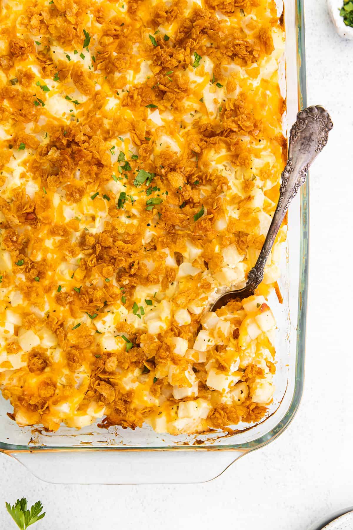 Cheesy hashbrown potatoes in a casserole dish.