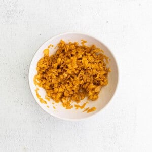 a bowl of shredded carrots on a white surface