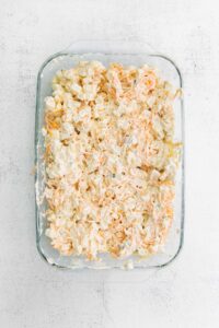 a cheesy casserole dish with shredded carrots.