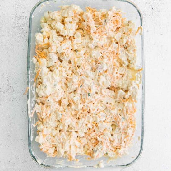 a cheesy casserole dish with shredded carrots.
