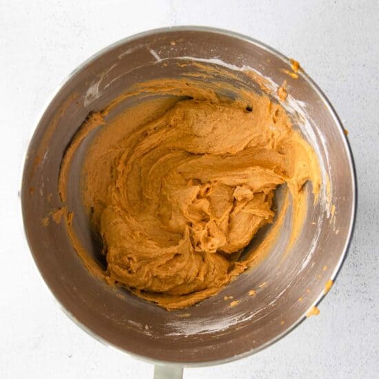 A mixing bowl filled with a pumpkin cream cheese bread mixture.