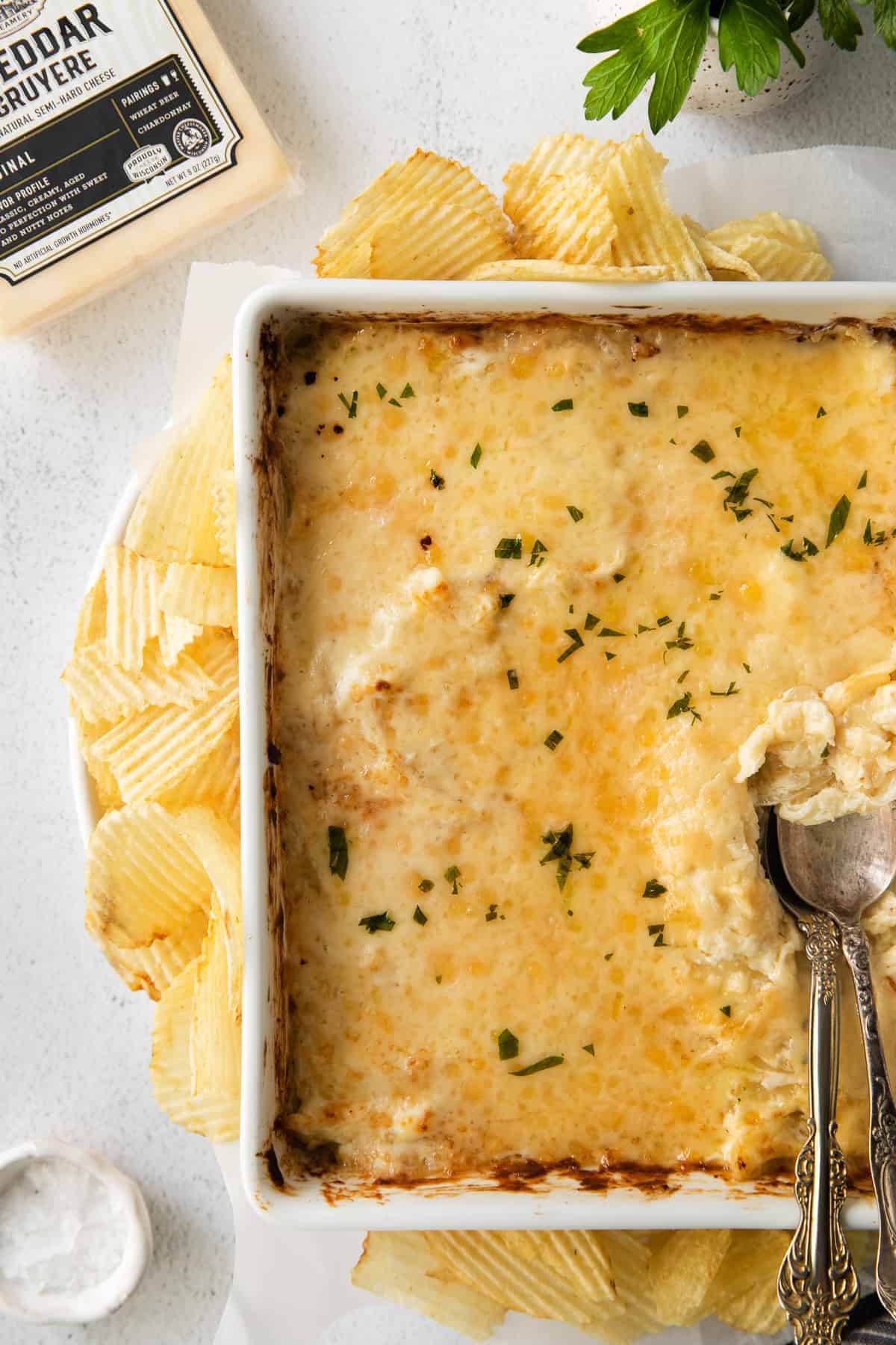 French onion dip in a casserole dish topped with fresh parsley.