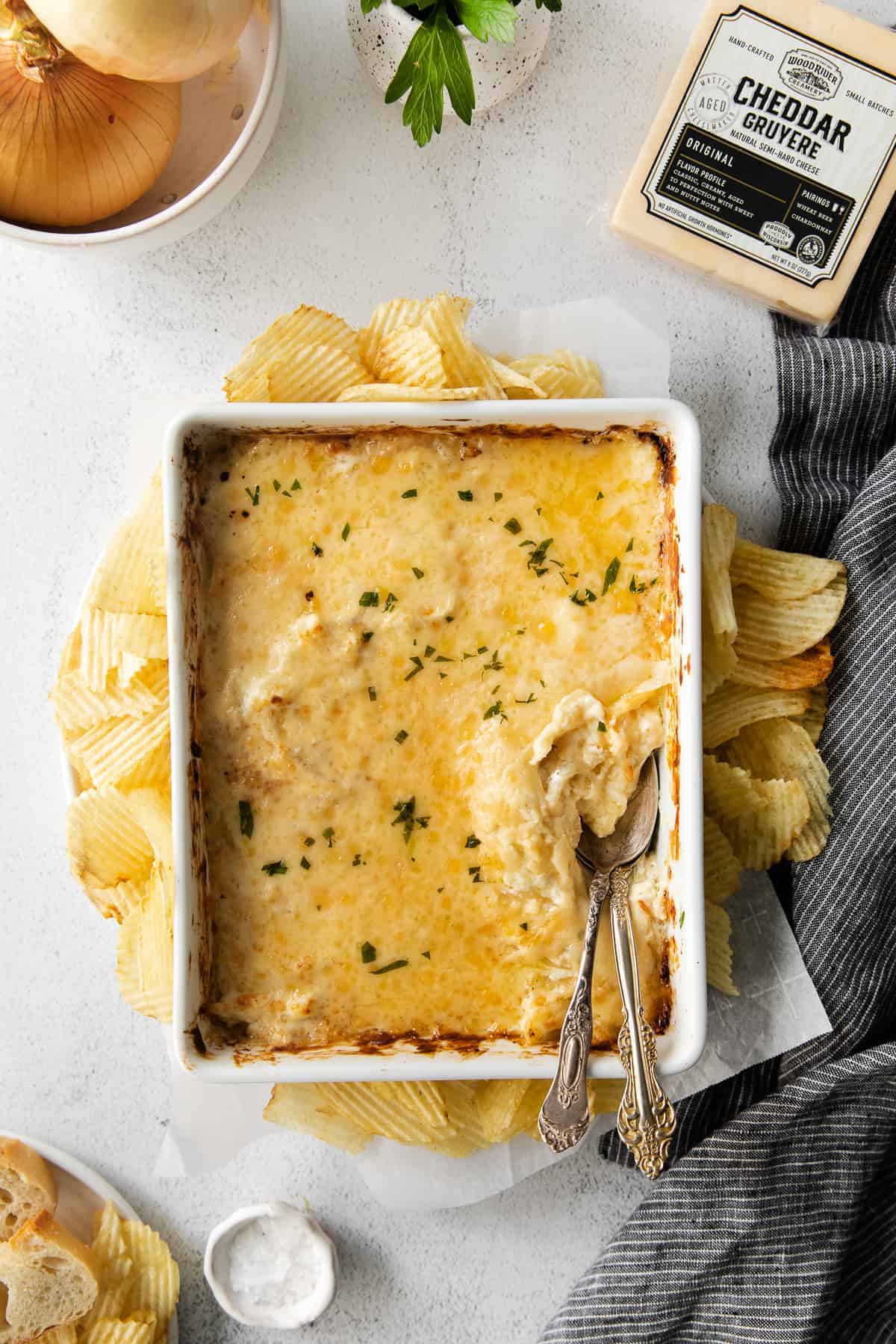 French onion dip in a casserole dish surrounded by potato chips.