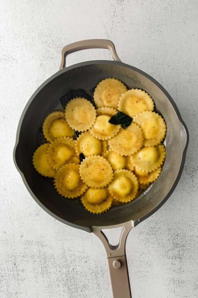goat cheese ravioli in a pan with brown butter sauce
