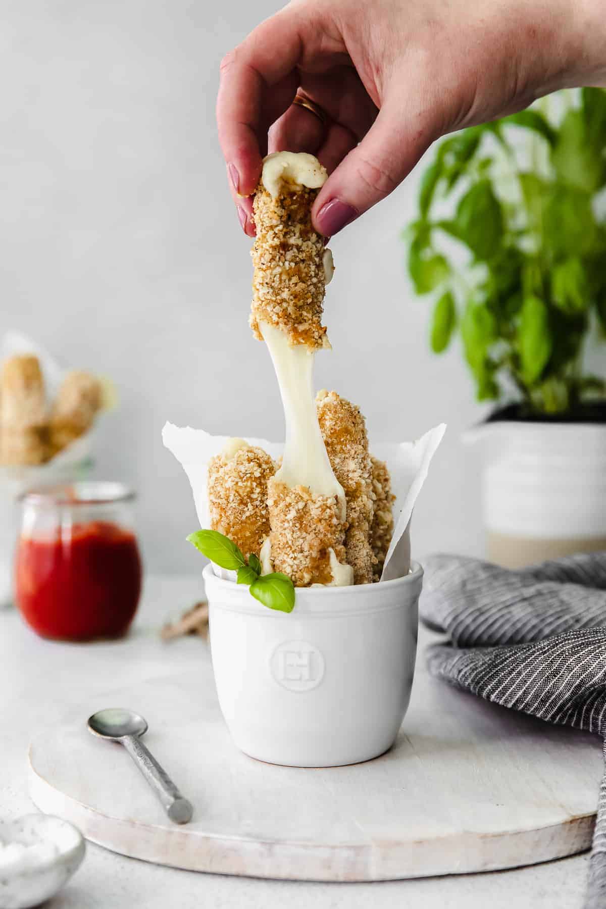 homemade mozzarella sticks being pulled apart by a hand