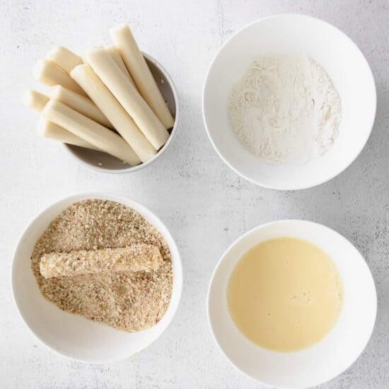 Four bowls with flour and butter, ready for making homemade mozzarella sticks.