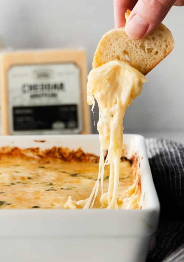 a crostini being dipped into cheese french onion dip