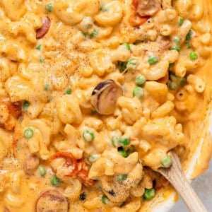 Macaroni and cheese in a casserole dish with a wooden spoon.