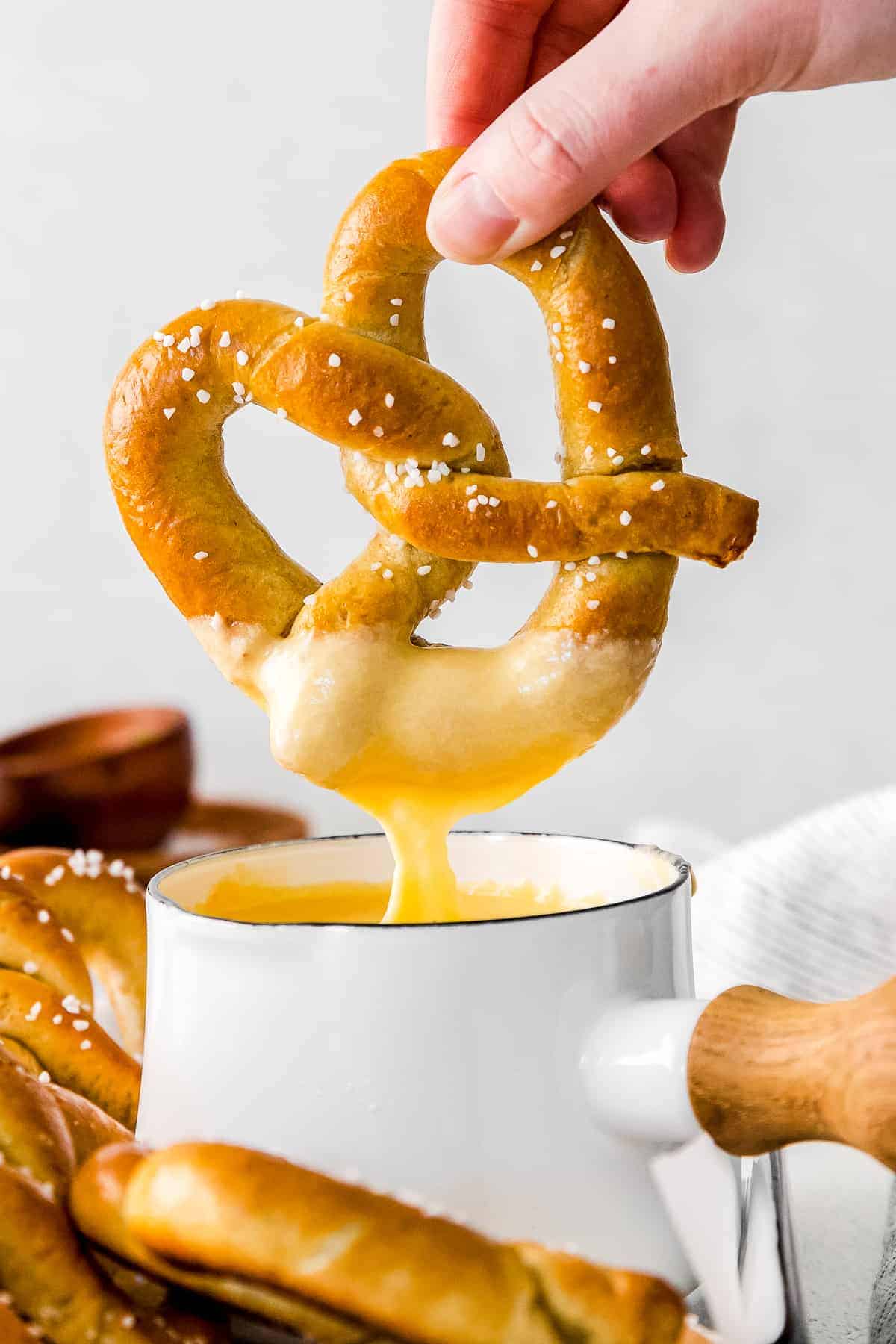 Dipping a pretzel into beer cheese dip. 