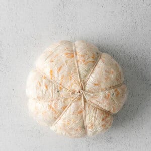 a stuffed pumpkin on a white surface.