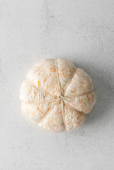 a stuffed pumpkin on a white surface.