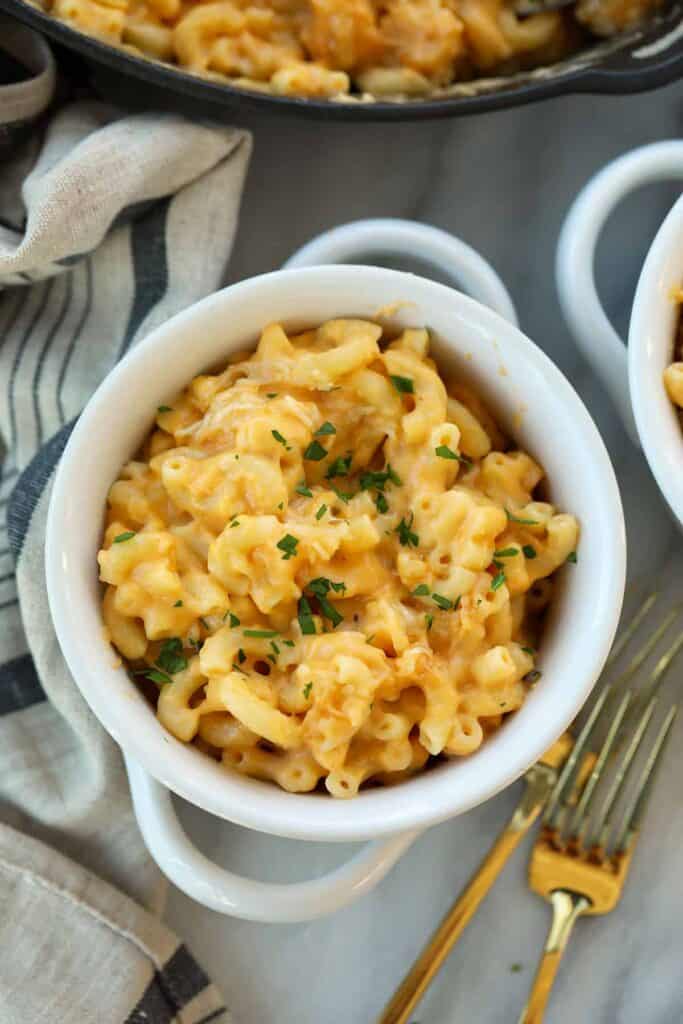 Smoked mac and cheese in a bowl topped with fresh parsley.