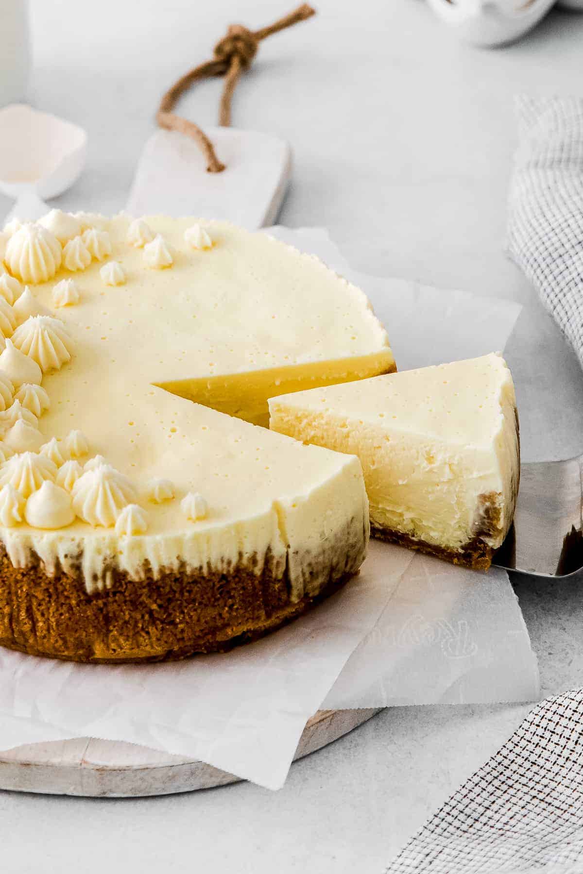 slice of instant pot cheesecake being taken out of the full cheesecake to be served