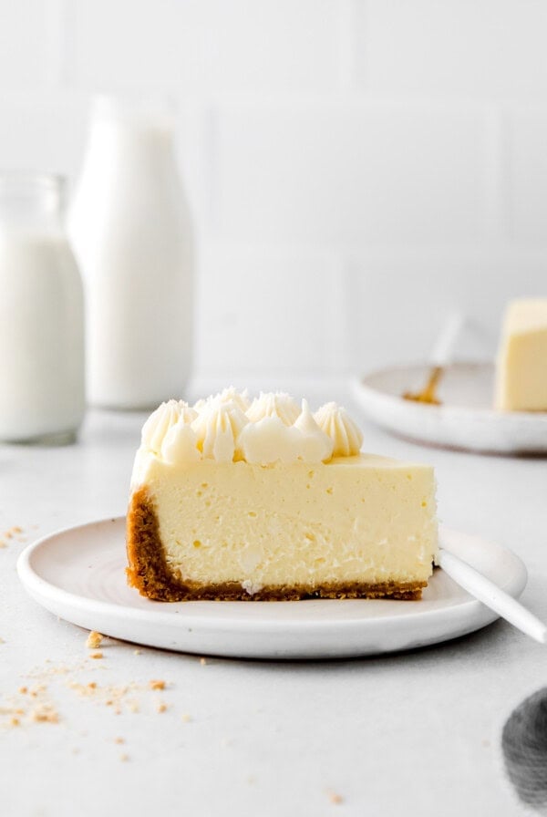 A slice of instant pot cheesecake on a white plate.