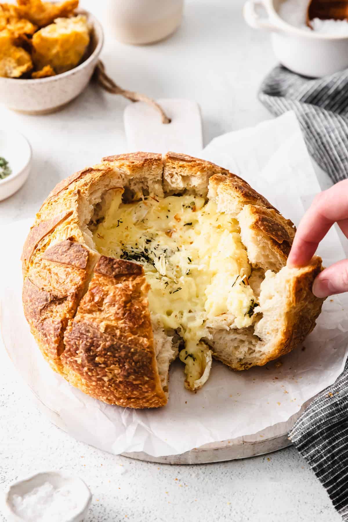 A simple baked brie in bread recipe made with a fresh sourdough loaf. Take your baked brie appetizer up a notch with this pull-apart idea. pulling apart sourdough