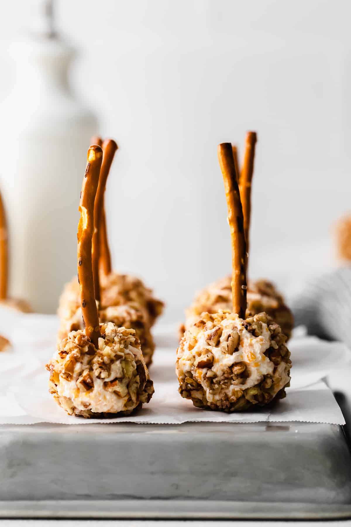 cheese ball bites with pretzel sticks stuck in them