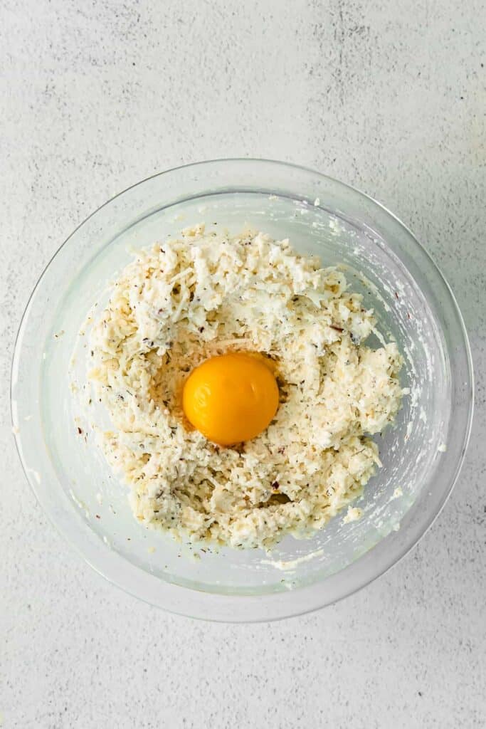 Ravioli filling in a bowl with an egg yolk.