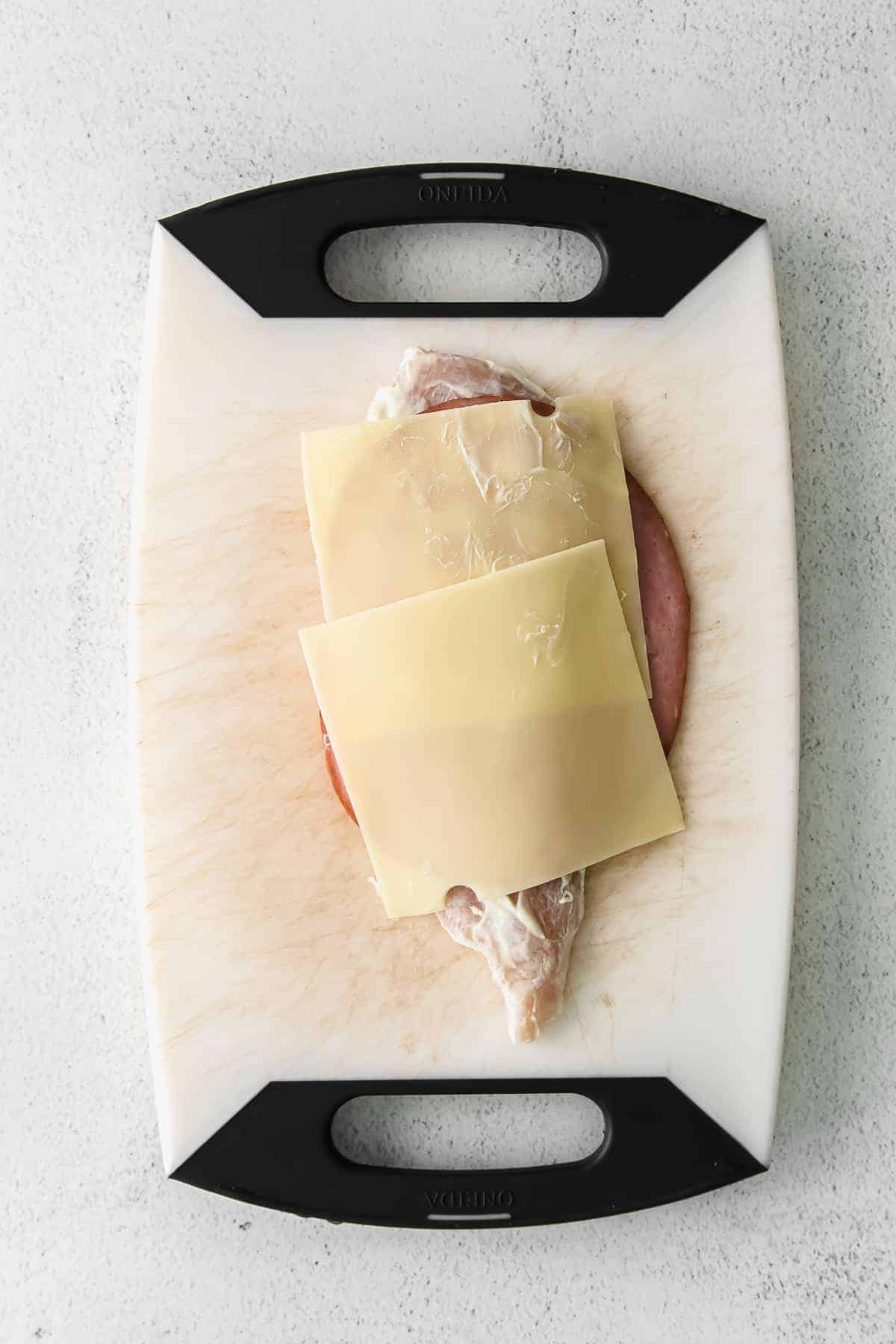 chicken cordon bleu being assembled on a cutting board