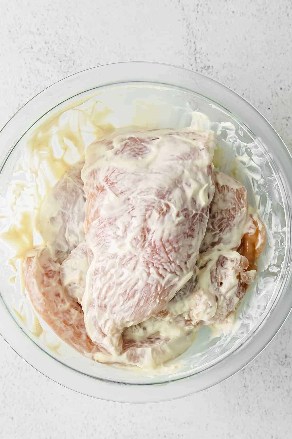 raw chicken in a greek yogurt sauce in a bowl