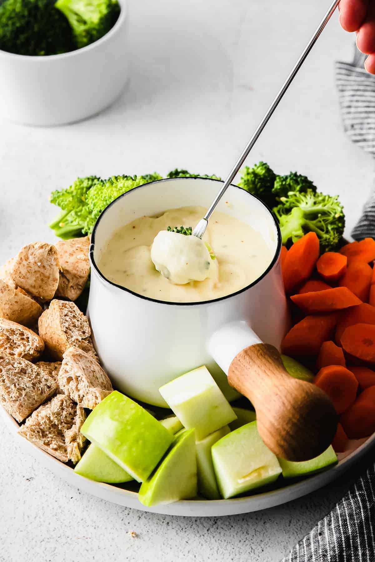 Dipping broccoli into a cheese fondue. 