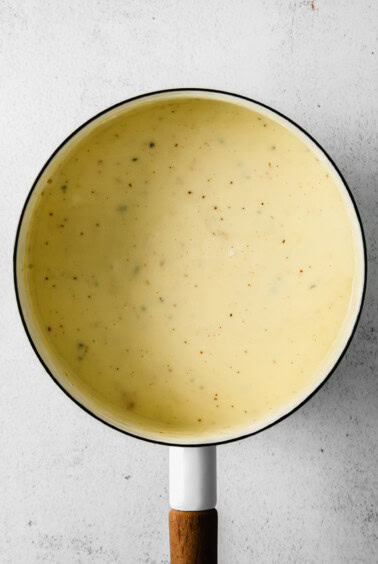 Smooth and creamy cheese fondue in a pot.