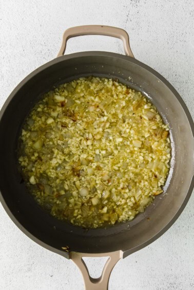a frying pan filled with onions and garlic.