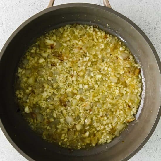 a frying pan filled with onions and garlic.