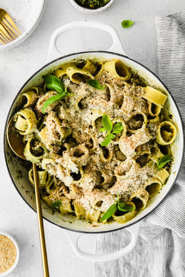 a dish of pasta with pesto and parmesan cheese.