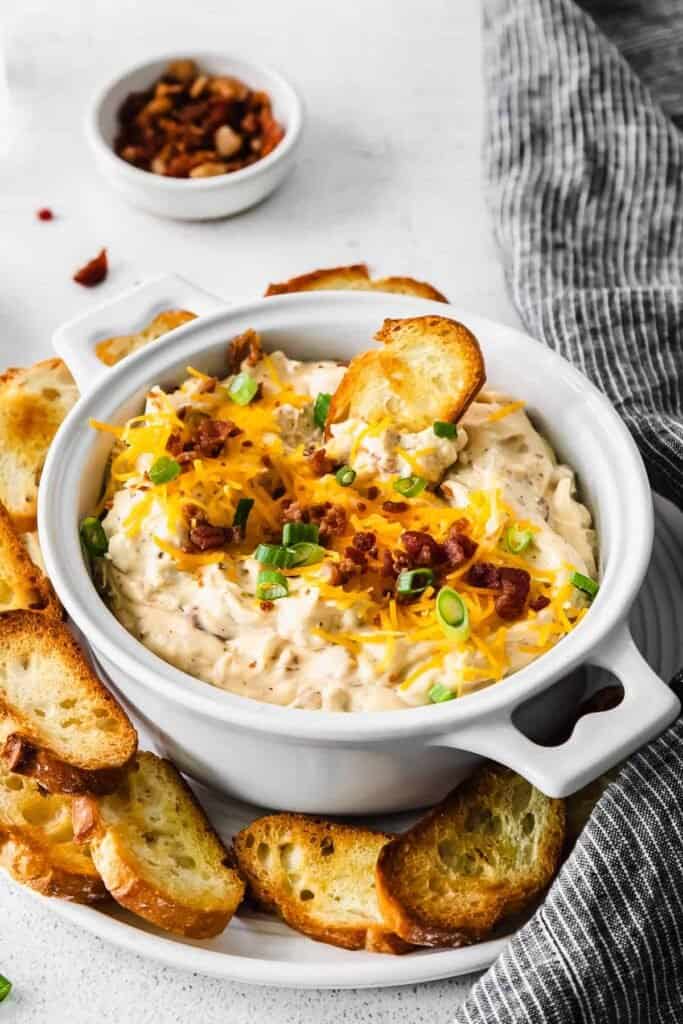 chicken bacon ranch dip in a bowl surrounded by crostini