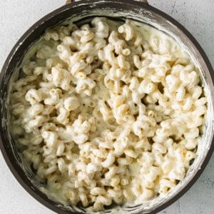 creamy pasta sauce over noodles in a skillet.