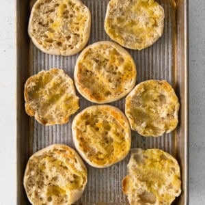 a baking sheet filled with a variety of breads on a white background.