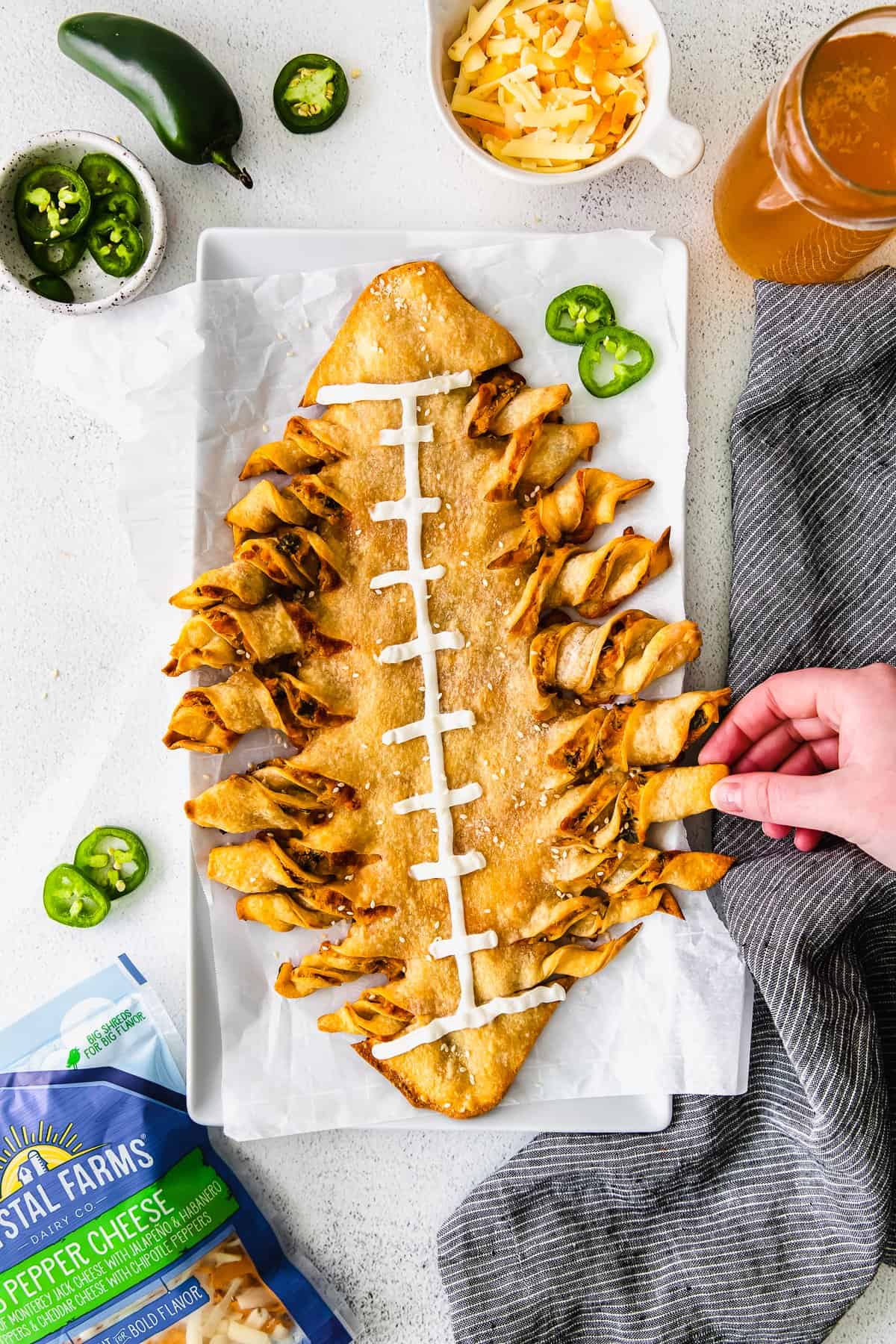 football-shaped cheesy breadsticks with a hand pulling off one breadstick