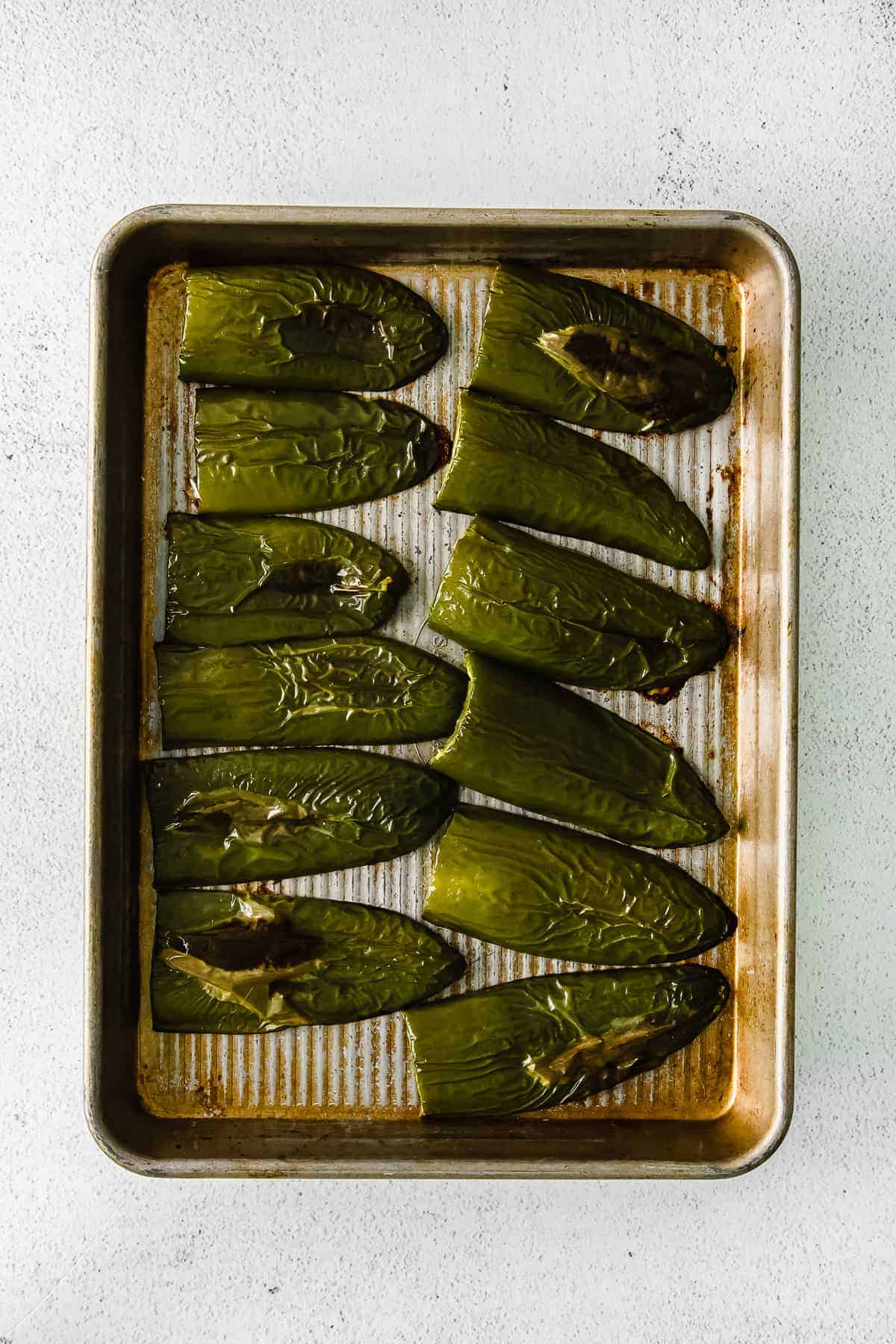 Roasted jalapeños on a baking sheet. 