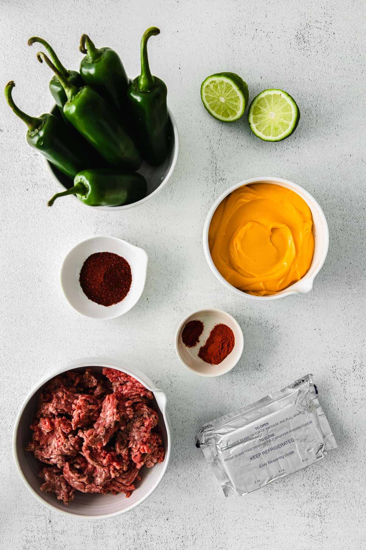 All the ingredients for jalapeno popper dip in small dishes. 