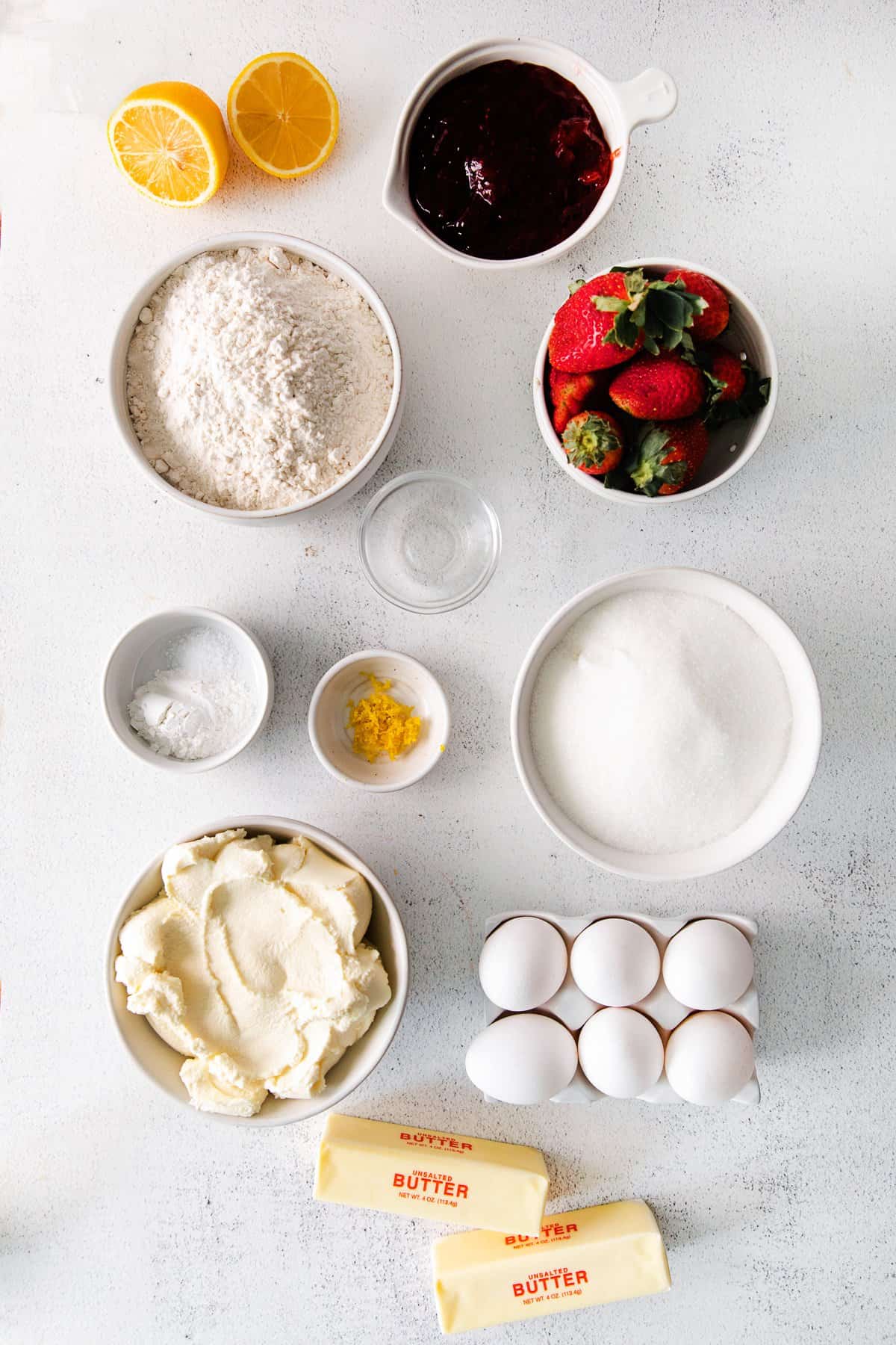 Flour, strawberries, strawberry jam, ricotta cheese, and other ingredients for this strawberry ricotta layer cake. 